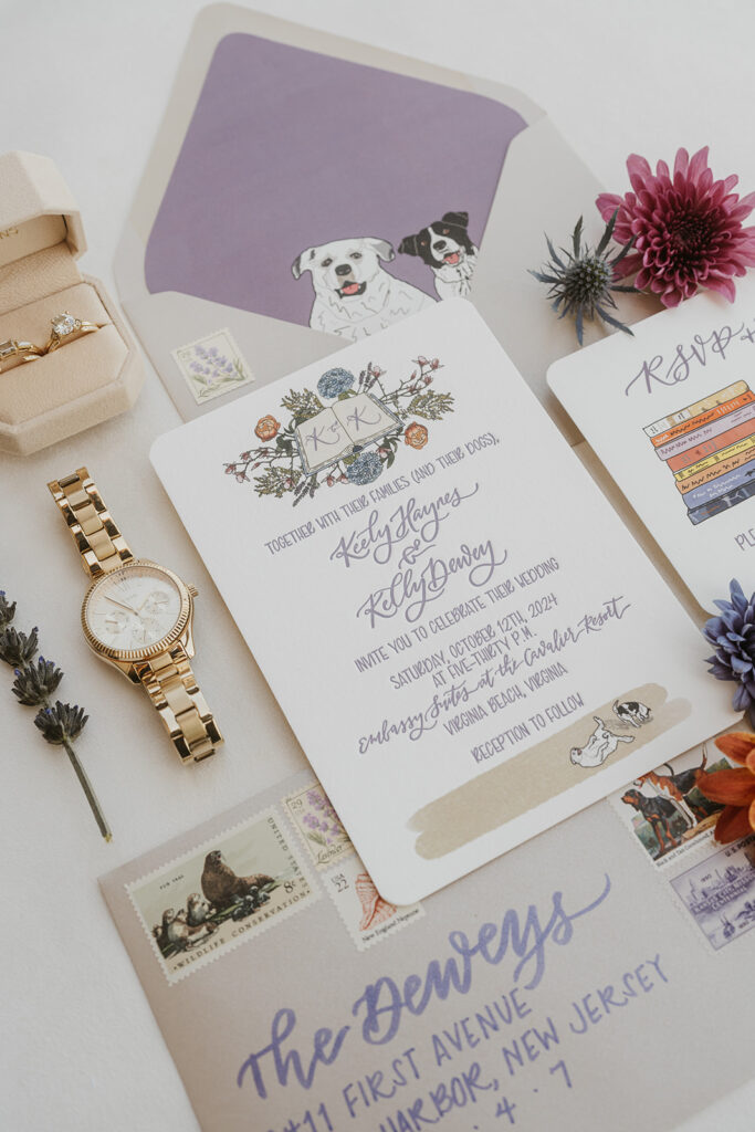 A set of wedding invitations, a watch and flowers laid out