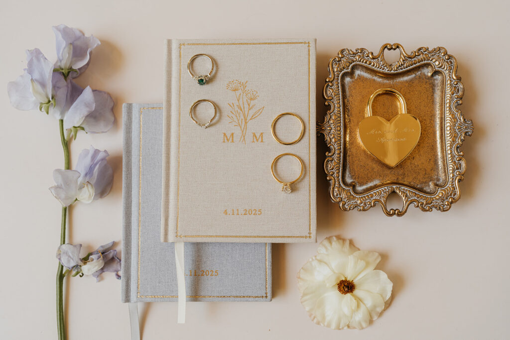 Vow books, wedding rings and florals laid out